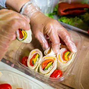 a person putting a sandwich in a container