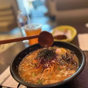 a bowl of soup with a wooden spoon