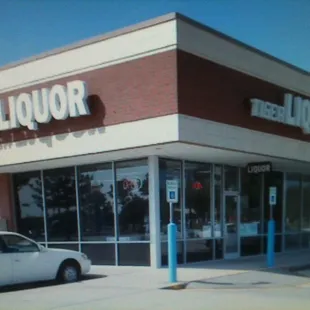 a white car parked in front of a liquor store