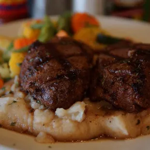 a plate of meat and mashed potatoes