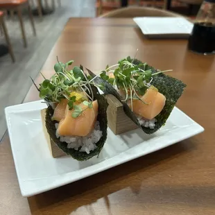 Specialty salmon hand roll - salmon, pickled shallot, lemon salt, yuzu-koso, sansho-oil, capers, micro green