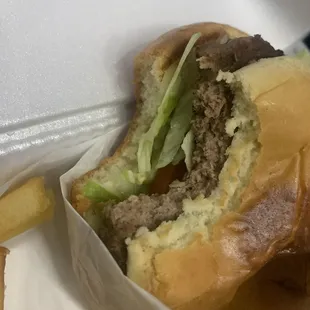 a hamburger and fries in a styrofoam container