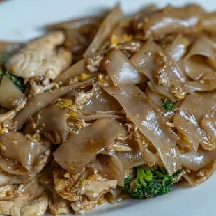 a plate of noodles with meat and broccoli