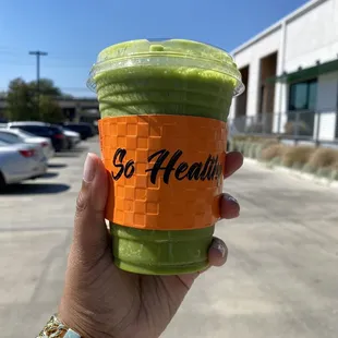 a hand holding a green smoothie