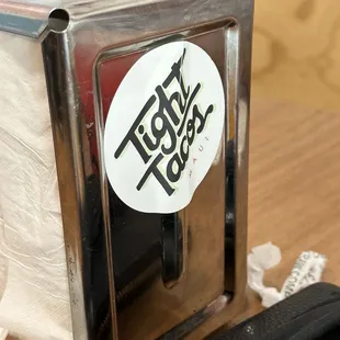 Napkin dispenser with &quot;Tight Tacos&quot; sticker