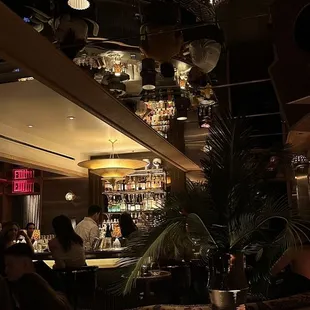 a dimly lit restaurant with a bar in the background