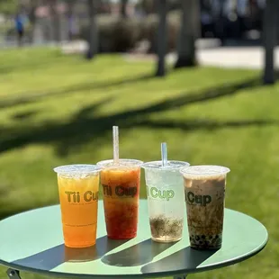 three drinks on a table in a park