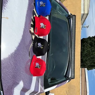 a pair of hats on the hood of a car