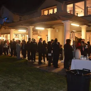 a large group of people standing in front of a house