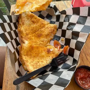 a person holding a piece of pizza