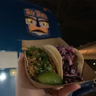 a hand holding a taco