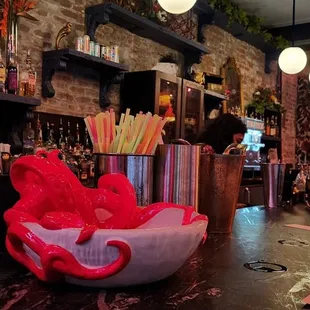 a red teddy bear in a bowl on a bar
