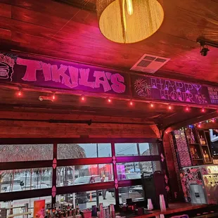 a neon sign above a bar