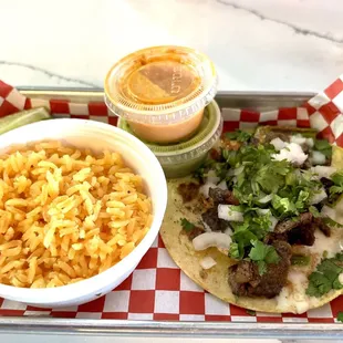 a taco, rice, and salsa on a tray