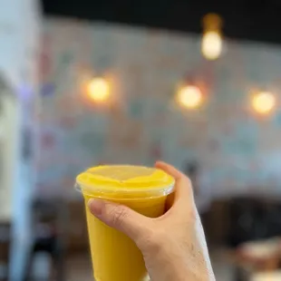 a hand holding a yellow cup