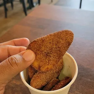 a hand holding a piece of bread