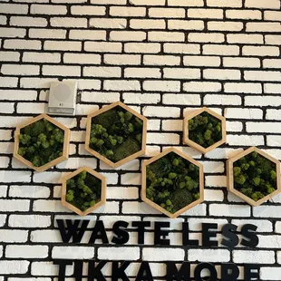 a brick wall with a sign that says waste less tikka more