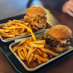 two trays of burgers and fries