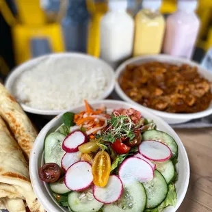 a bowl of salad, a tortilla, and a tortilla