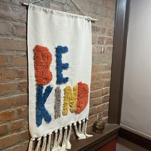 a wall hanging on a brick wall