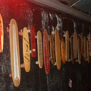 a row of skateboards hanging on a wall