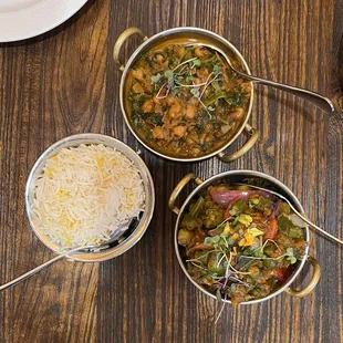 three bowls of food on a wooden table