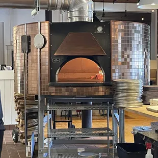 a man standing in front of a pizza oven