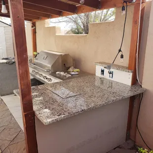 an outdoor kitchen with granite counter tops