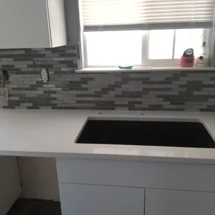 a kitchen counter with a sink and a window
