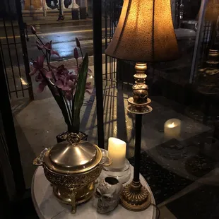 a table with a lamp and a candle