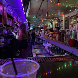 a woman sitting at a bar with a drink in her hand