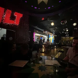 a group of people sitting at a table in a bar