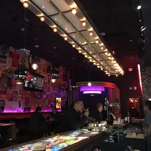 people sitting at a bar with neon lights