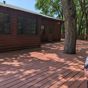 a young boy standing on a deck in front of a cabin
