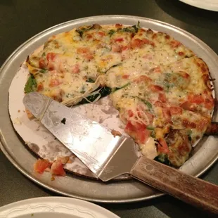 Spinach Alfredo pizza with mushrooms and tomatoes