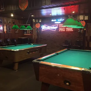 two pool tables and a neon sign