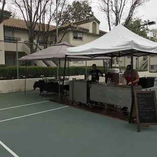 a tennis court with tables and chairs