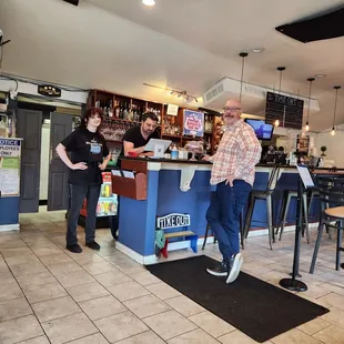 two people standing at a bar