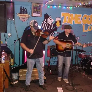 two men playing guitar and singing