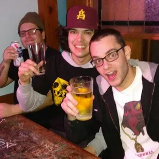 three men drinking beer and smiling