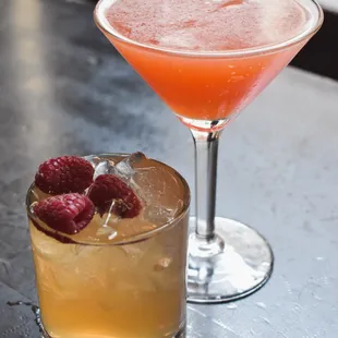a cocktail and a raspberry cocktail on a table