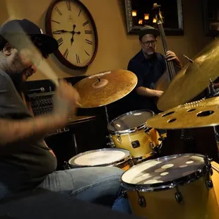 two men playing drums in a music studio