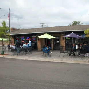 people sitting outside under umbrellas
