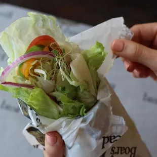 a hand holding a sandwich