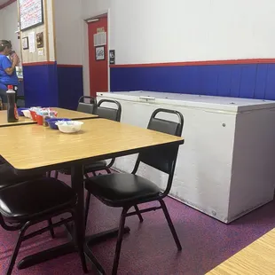 a table with chairs and a refrigerator