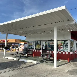 Front door with two tables outside for seating