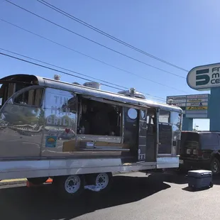a silver camper parked in a parking lot