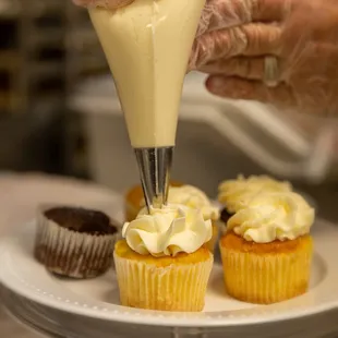 a person decorating cupcakes