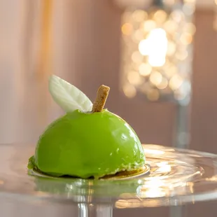 a green apple on a glass plate