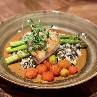 Halibut with tomatoes, wild and long grain rice, lobster nage sauce, and pea tendrils